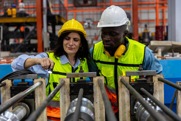 Female mechanical engineer is coaching and providing support to her trainee while examining the...