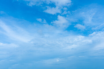 Fluffy white clouds drift across a vibrant blue sky, creating a breathtaking natural masterpiece