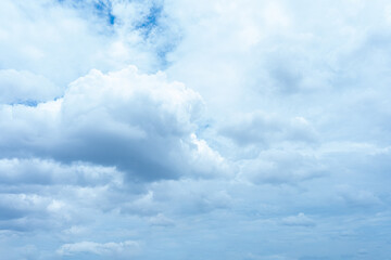Fluffy white clouds drift across a clear blue sky, painting a beautiful landscape of nature's artistry
