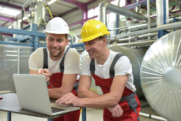 Mechanics repair a machine in a modern industrial plant - profession and teamwork