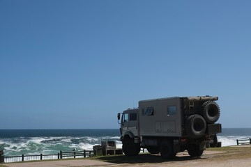 Camper truck parked on a campsite next to the sea, view from the side © Aniek