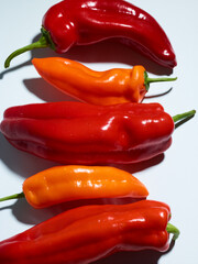 Pile of bell and long sweet peppers over pink background