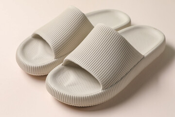 Pair of rubber slippers on beige background, closeup