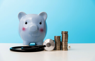 Piggy bank with stethoscope on the table