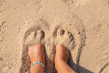 Woman's feet on the sand at the sea. Selective focus.