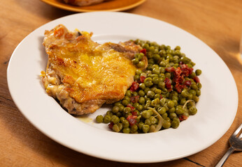 Delicious crispy chicken with peas as a side dish on a plate