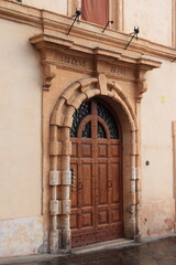 Naklejka premium Wooden Building Entrance with Sculpted Stone Frame in Assisi, Italy