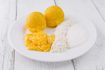 Delicious breakfast is served on a white plate standing on white wooden planks