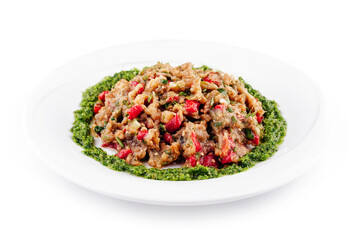 Delicious eggplant salad with green pesto decorating a white plate