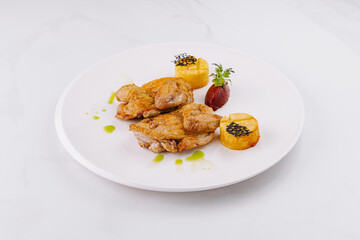 Delicious roasted chicken dish with potatoes and sauce being served on white plate