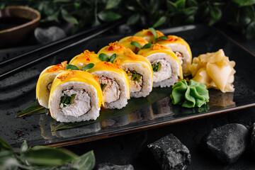 Mango sushi rolls presenting filling on dark plate with wasabi and ginger
