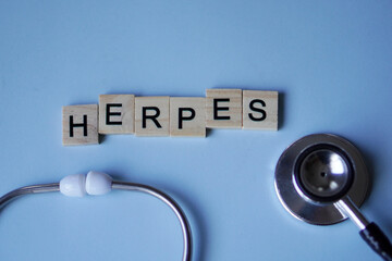 HERPES, wooden letters with stethoscope on light blue background. medicine concepts