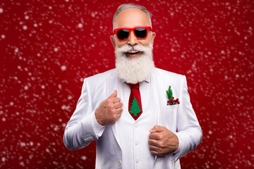 Photo of funky cool mature man dressed white christmas costume dark glasses smiling isolated red...
