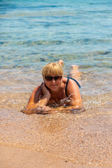 Woman relaxing on the beach in the sea. Selective focus.