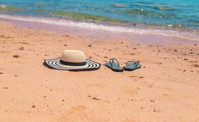 Hat and beach flip-flops. Selective focus.