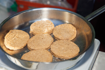 Delicious, golden brown, flat bread slices frying in a hot pan, savory food, healthy eating concept