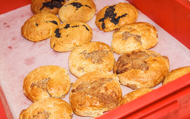Freshly baked cookies on red tray, golden brown cookies with chocolate chips and nuts, homemade pastries, delicious dessert concept