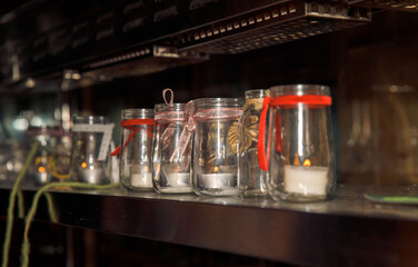 Row of decorative glass jars with candles and ribbons, cozy atmosphere, home decor concept