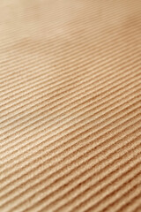 Obraz premium Close-up of a fabric surface with a diagonal ribbed texture in warm tan brown color, offering a cozy and tactile appeal for background or design use.