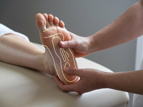 Reflexology massage in progress, focusing on foot to promote relaxation and wellness. therapists hands apply pressure to specific points, enhancing overall health