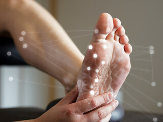 A reflexology massage is being performed on persons foot, highlighting connection between foot and various body points. This soothing treatment promotes relaxation and well being