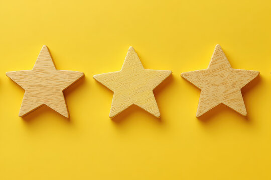 Three wooden stars arranged in a row on a vibrant yellow background, offering a cheerful and positive visual aesthetic.