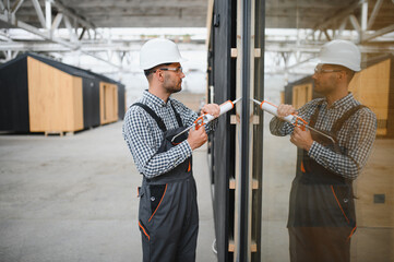 A worker installs windows in a new modular home. The concept of a new home