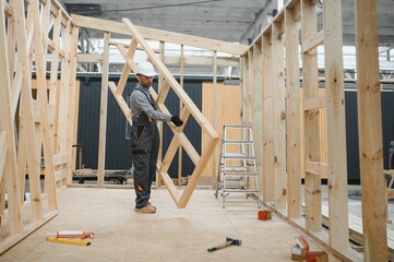 Process of construction new and modern modular house. Worker man in special protective uniform wear working on building development industry of energy efficient property