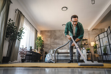 Adult man vacuum living room with modern decor and natural light