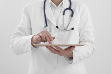 Doctor with tablet on white background, closeup view