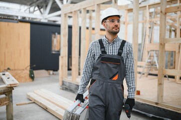 Worker carpenter assembling a modular house
