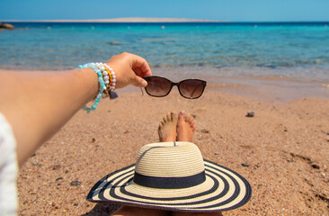 Obraz premium Sunglasses in hands at sea. Selective focus.