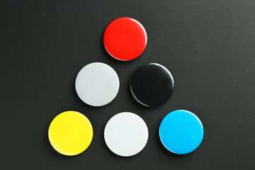 Button badges on black background, flat lay. Mockup for design