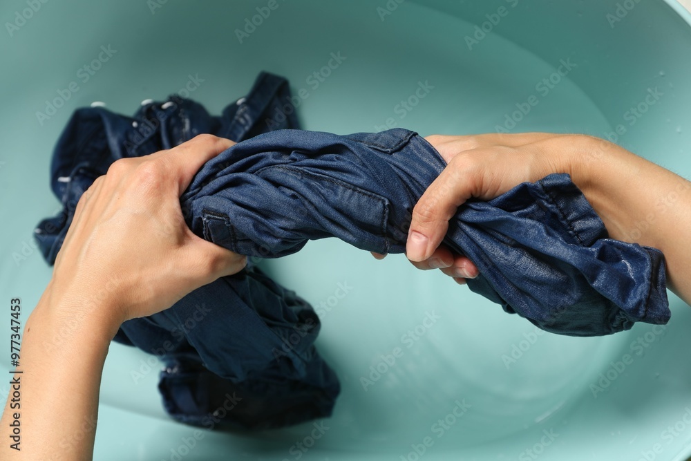 Canvas Prints Woman washing denim clothes in basin, top view