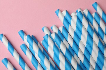 Fototapeta premium Bamboo drinking straws on pink background, top view