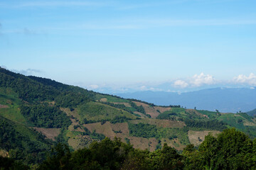 Fototapeta premium The perspective of the mountain range and clouds in the blue sky background