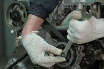 Repair of an automobile engine at a service center. An auto mechanic replaces the timing belt. A...