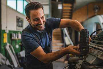 Car mechanic work on vehicle with drill tool in repair garage shop