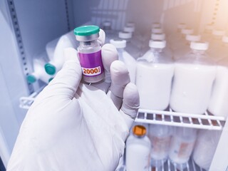 Someone is taking a vial of animal vaccine inside the vaccine laboratory showcase.