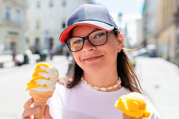 Beautiful young woman eating ice cream in the city, summertime