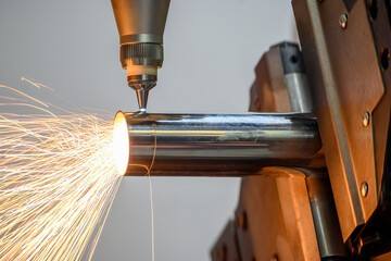 Close up scene the fiber laser cutting machine cut the stainless steel tube and laser beam light.