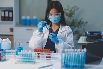 Fototapeta premium Group of dedicated scientist conduct chemical experiment in medical laboratory, carefully drop precise amount of liquid from pipette into test tube for vaccine drug or antibiotic development. Neoteric