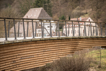 Detail Holzbrücke mit Betonplatten vor historischen Gebäuden