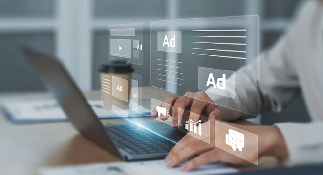 Digital marketing concept with businessman using computer laptop creating online adverts to increase sales. Using social media and websites for traffic and awareness, working in a modern office.