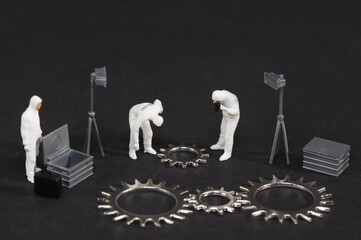 A team in protective suits inspecting steel gears