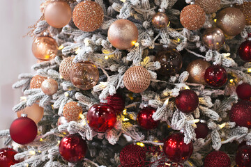 Decorated xmas tree with fake snow and red sparkly balls.