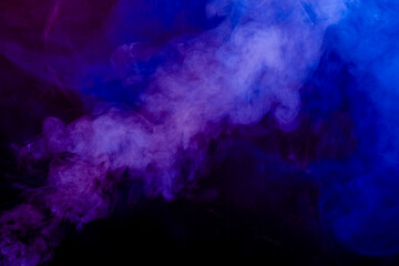 Volutes de fumée flottant sur un fond noir.