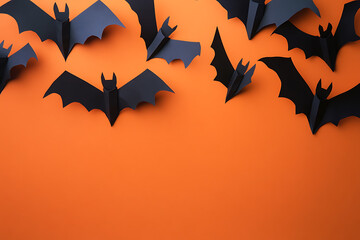 Fototapeta premium A collection of black paper bats against an orange background, ideal for Halloween decor.