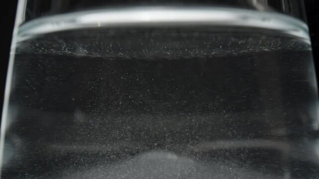 More undissolved powder particles spinning in the water, highlighting the mixing process.