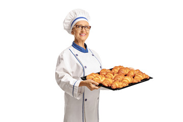 Female chef holding a tray with croissants
